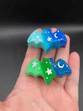 Load image into Gallery viewer, Cute and spooky magnet design to adorn your refrigerator, lockers, workstation, toolbox, or dishwasher. This hand-sculpted clay bat statuette boasts stunning ombre coloration, transitioning from dark blue to light blue and dark blue to dark and then light green to recreate the breathtaking look of a starry night sky. H 1” x W 2” x D 1/2”