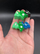 Load image into Gallery viewer, Cute and spooky magnet design to adorn your refrigerator, lockers, workstation, toolbox, or dishwasher. This hand-sculpted clay bat statuette boasts stunning ombre coloration, transitioning from dark blue to light green and black, to dark green to light green to recreate the breathtaking look of a starry night sky. H 1” x W 2” x D 1/2”