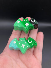 Load image into Gallery viewer, Cute and spooky magnet design to adorn your refrigerator, lockers, workstation, toolbox, or dishwasher. This hand-sculpted clay bat statuette boasts stunning ombre coloration, transitioning from black to dark green to light green and dark to light green to light blue to recreate the breathtaking look of a starry night sky. H 1” x W 2” x D 1/2”