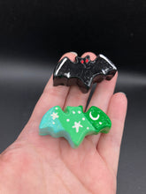 Load image into Gallery viewer, Cute and spooky magnet design to adorn your refrigerator, lockers, workstation, toolbox, or dishwasher. This hand-sculpted clay bat statuette boasts stunning ombre coloration, transitioning from dark green to light green then to light blue and all black bat with white highlights to recreate the breathtaking look of a starry night sky. H 1” x W 2” x D 1/2”