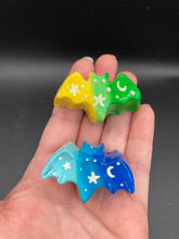 Load image into Gallery viewer, Cute and spooky magnet design to adorn your refrigerator, lockers, workstation, toolbox, or dishwasher. This hand-sculpted clay bat statuette boasts stunning ombre coloration, transitioning from dark blue to light blue and dark to light green and then to light yellow to recreate the breathtaking look of a starry night sky. H 1” x W 2” x D 1/2”