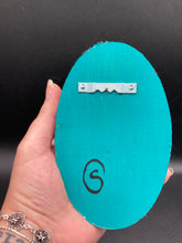 Load image into Gallery viewer, This Sacred Heart Wall Art Decor is the perfect way to enhance your home with an artistic flair. This beautiful artwork features a bright turquoise wooden frame with a hand-crafted bright red heart. The heart is detailed with dark red rose and vibrant green leaves, with a vibrant fire embellishment over the center. Gold decorative embellishments at the sides of the heart add a luxurious touch. H 5 3/8" x W 3 3/8” x D 1 1/2"