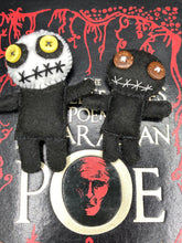 Load image into Gallery viewer, Creepy black and white Voodoo Doll stands tall at 4" in height. He’s all black like a shadow but has a round white head. Bright yellow buttons eyes are perfect to see you better with. Creepy black and white Voodoo Doll stands tall at 4" in height. He’s all black like a shadow but has a round white head. Bright yellow buttons eyes are perfect to see you better with.