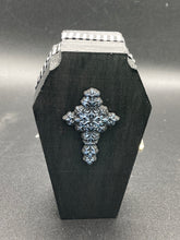 Load image into Gallery viewer, This unique vintage-inspired ring box is perfect for storing your jewelry and other special items. The wood coffin design is accented with a detailed floral black silver cross and a white and black ribbon. The interior is lined with a skull fabric and a fleur de lis embellishment, adding a spooky yet cute flair.