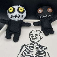 Load image into Gallery viewer, Creepy black and white Voodoo Doll stands tall at 4" in height. He’s all black like a shadow but has a round white head. Bright yellow buttons eyes are perfect to see you better with. Creepy black and white Voodoo Doll stands tall at 4" in height. He’s all black like a shadow but has a round white head. Bright yellow buttons eyes are perfect to see you better with.