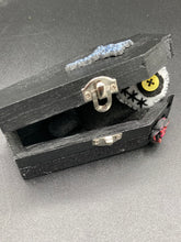 Load image into Gallery viewer, Creepy black and white Voodoo Doll stands tall at 4" in height. He’s all black like a shadow but has a round white head. Bright yellow buttons eyes are perfect to see you better with.