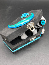 Load image into Gallery viewer, Black and white Voodoo Doll has a black torso, white arms and legs and both round white head with bulging large turquoise buttons, he’s just funny looking. 3 1/2" in height