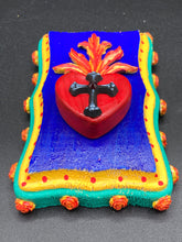 Load image into Gallery viewer, This Sacred Heart Wall Art Decor is the perfect way to enhance your home with an artistic flair. This Sacred Heart Wall Art Decor is crafted with a stunning red heart detailed with a black-silver cross and a vibrant fire embellishment at its center. Adding to its unique traditional Mexican aesthetic, the wood frame is decorated with marigold flowers, creating a beautiful and eye-catching artwork.