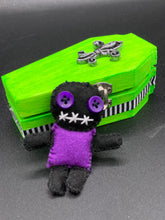Load image into Gallery viewer, Short and tiny black and purple Voodoo Doll is 3" in height. Torso is purple while legs and arms and head are all black like the night. He has matching purple buttons for eyes and has a sowed shut mouth.