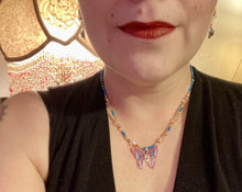 Load image into Gallery viewer, This delicate butterfly pendant is crafted from a basil leaf and adorned with accents of pink, gold and blue. A shining glass beaded necklace crafted from beads of varying shades of pink, gold, and blue, creates a beautiful accompaniment to the butterfly wings. Wear this ravishing necklace and butterfly jewelry pendant to embody the spirit of warm Spring and Summer days. 16 1/4” in length adjustable up to 18"