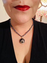 Load image into Gallery viewer, This stylish necklace features a shimmery sterling silver amethys pendant with cats and stars, making it the perfect accessory for any cat lover. With two-hole blue beads compliments the dark dark purple hues glass beads, this double strand necklace holds a round kitty pendant made with various hues of purple, blue and gold tone glass beads. Add a touch of purrfection to your look with this statement piece.   Measurements:  Necklace is 15 1/2” adjustable up to 18"