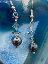 Load image into Gallery viewer, These stunning hematite and glass beaded earrings are a perfect combination of shabby boho chic and bohemian style. The round hematite beads are beautifully complemented by the light blue triangle shaped glass beads, for an eye-catching accessory that is sure to draw attention.  Measurements: 1 1/4” in length