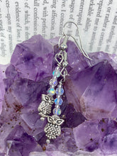Load image into Gallery viewer, These sleek earrings feature tiny glass beads with a shimmery iridescent and silver finish, along with silver-plated owls for a stylish touch. Measurements: 1 1/4” in length