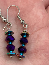 Load image into Gallery viewer, These rainbow hematite and dark purple glass beaded earrings are the ideal accessory for bohemian summer looks, providing a touch of chic elegance to hippie and nature-inspired styles. Measurements: 1” in length