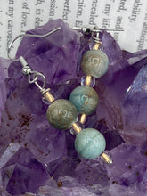 Load image into Gallery viewer, These mossy green round ceramic beads are paired with gold tone glass beads for an earthy and stylish set of earrings. Measurements: 1"