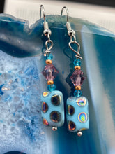 Load image into Gallery viewer, These whimsical earrings feature an eye-catching blend of bright blue glass beads, which feature a blend of blues, purples, and hints of gold. They are further complemented by varying sizes and shapes to create a unique texture and style. This vibrant jewelry is a must-have for any collection. Measurements: 1 ” in length