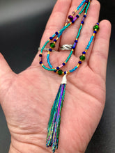 Load image into Gallery viewer, This Celestial and Galaxy Vibe Necklace features a 2 1/2" long Rainbow Kyanite Wired Stone pendant and two strands of multi-color glass beaded necklaces. The glass beads are an eclectic mix of sizes and shapes, including rectangular hematite beads, creating a shimmery, bold display of purples, blues, greens and golds. This necklace truly captures the essence of this celestial galaxy stone.Necklace is 15 1/2” in length can be adjusted to 18" in length
