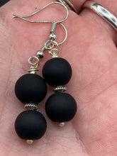 Load image into Gallery viewer, These two-bead flat matte black glass earrings are perfect for any look. With their subtle yet elegant design, they are a great accessory for any closet. 1 1/4” in length