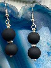 Load image into Gallery viewer, These two-bead flat matte black glass earrings are perfect for any look. With their subtle yet elegant design, they are a great accessory for any closet. 1 1/4” in length