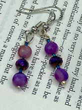 Load image into Gallery viewer, These elegant, glass beaded earrings feature dainty light and dark purple hues, making them a great addition to any summer wardrobe. Perfect for hippie and nature-inspired looks, they are sure to accentuate any style. Measurements: 1 ” in length