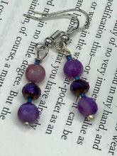 Load image into Gallery viewer, These elegant, glass beaded earrings feature dainty light and dark purple hues, making them a great addition to any summer wardrobe. Perfect for hippie and nature-inspired looks, they are sure to accentuate any style.  Measurements: 1 ” in length