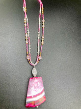 Load image into Gallery viewer, This large agate pendant features a variety of pink hues, from light to dark, and is accompanied by two strands of glass beaded necklaces with pink, silver, gold, and clear beads. The combination of colors creates a stunning and vibrant look, perfect for accessorizing any summer look. Measurements: Necklace is 15” adjustable up to 18" in length