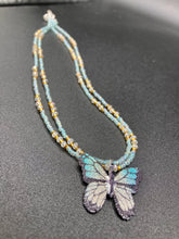 Load image into Gallery viewer, This precious sterling silver pendant features a hand-crafted butterfly whose wings have been artistically molded from a basil leaf and painted in a trio of light blue, silver, and gold hues. Accompanying the butterfly pendant are two glass beaded necklaces in an alluring combination of light blue, gold, and medium-small clear glass beads. A stunning summer accessory.  Measurements:  Necklace is 16” adjustable up to 18" in length