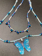 Load image into Gallery viewer, This Sterling Silver Bright Sky Blue and Silver Butterfly Pendant is detailed with a basil leaf motif. With vibrant hues of blue and silver, the pendant is complimented by multi-color glass beads to create the ideal summer jewelry piece.  Measurements:  Necklace is 16 1/2”adjustable up to 18"