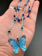Load image into Gallery viewer, This Sterling Silver Bright Sky Blue and Silver Butterfly Pendant is detailed with a basil leaf motif. With vibrant hues of blue and silver, the pendant is complimented by multi-color glass beads to create the ideal summer jewelry piece.  Measurements:  Necklace is 16 1/2”adjustable up to 18"