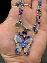 Load image into Gallery viewer, This Sterling Silver Dark Blue, Silver and Gold Butterfly Pendant is handcrafted from a basil leaf, and is meticulously painted in brilliant blues and silver. A range of multi-colored glass beads from deep blue to pale silver and gold tones combine to create a stunning lapis stone-like effect. This nature-inspired jewelry piece is perfect for adding a touch of summery style to any look.  Measurements:   Necklace is 15 1/2” adjustable up to 18"