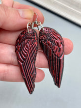 Load image into Gallery viewer, Red angel wings earrings made of polymer clay. These earrings are designed to face forward when worn instead of the front wings showing on the side.