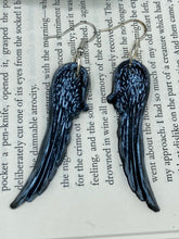 Load image into Gallery viewer, Shimmery silver color angel wings earrings made of polymer clay. These earrings are designed to face forward when worn instead of the front wings showing on the side.