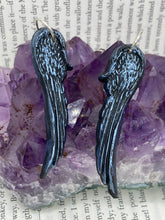 Load image into Gallery viewer, Shimmery silver color angel wings earrings made of polymer clay. These earrings are designed to face forward when worn instead of the front wings showing on the side.