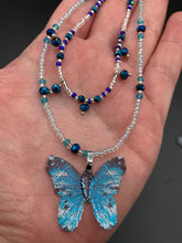 Load image into Gallery viewer, This Sterling Silver Bright Sky Blue and Silver Butterfly Pendant is detailed with a basil leaf motif. With vibrant hues of blue and silver, the pendant is complimented by multi-color glass beads to create the ideal summer jewelry piece.  Measurements:  Necklace is 16 1/2”adjustable up to 18"