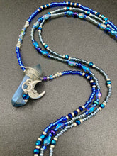 Load image into Gallery viewer, This jewelry piece is a delicate harmony of light and dark tones. Three strands feature a mix of navy blue, pewter, and oval-shaped, light blue-gray beads with a subtle iridescence of amethyst, emerald, and gold. Its celestial theme and bold composition create an alluringly elegant accessory. This whimsical necklace boasts a wonderfully unique aesthetic, featuring a wired blue luster nugget and a whimsical crescent moon charm. Measurements: Necklace is 15 1/4”adjustable up to 18"