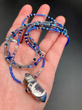 Load image into Gallery viewer, This jewelry piece is a delicate harmony of light and dark tones. Three strands feature a mix of navy blue, pewter, and oval-shaped, light blue-gray beads with a subtle iridescence of amethyst, emerald, and gold. Its celestial theme and bold composition create an alluringly elegant accessory. This whimsical necklace boasts a wonderfully unique aesthetic, featuring a wired blue luster nugget and a whimsical crescent moon charm. Measurements: Necklace is 15 1/4”adjustable up to 18"