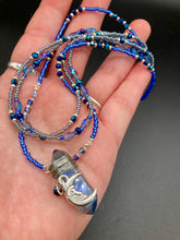 Load image into Gallery viewer, This jewelry piece is a delicate harmony of light and dark tones. Three strands feature a mix of navy blue, pewter, and oval-shaped, light blue-gray beads with a subtle iridescence of amethyst, emerald, and gold. Its celestial theme and bold composition create an alluringly elegant accessory. This whimsical necklace boasts a wonderfully unique aesthetic, featuring a wired blue luster nugget and a whimsical crescent moon charm. Measurements: Necklace is 15 1/4”adjustable up to 18"