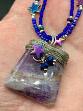 Load image into Gallery viewer, This elegant amethyst trapezoid pendant is artfully wirewrapped with a hematite star bead, making this a unique piece perfect for any occasion. Its two strands of colorful glass beads in a mix of cool blues, purples, and silver create an enchanting, starry night look sure to make a statement. Necklace is 16” in length and can be adjusted to 18"