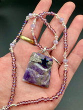 Load image into Gallery viewer, This sophisticated trapezoid-shaped wired amethyst pendant featuring a hematite star bead provides a unique, star-studded night sky look. Multicolored glass beads in shades of pink, purple, blue and gold feature along a single-stranded necklace, intermixed with larger, soft dusty rose glass beads and iridescent beads for a subtle shimmer. Necklace is 17" length can be adjusted to 18"
