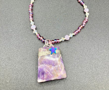 Load image into Gallery viewer, This sophisticated trapezoid-shaped wired amethyst pendant featuring a hematite star bead provides a unique, star-studded night sky look. Multicolored glass beads in shades of pink, purple, blue and gold feature along a single-stranded necklace, intermixed with larger, soft dusty rose glass beads and iridescent beads for a subtle shimmer. Necklace is 17" length can be adjusted to 18"