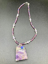 Load image into Gallery viewer, This sophisticated trapezoid-shaped wired amethyst pendant featuring a hematite star bead provides a unique, star-studded night sky look. Multicolored glass beads in shades of pink, purple, blue and gold feature along a single-stranded necklace, intermixed with larger, soft dusty rose glass beads and iridescent beads for a subtle shimmer. Necklace is 17" length can be adjusted to 18"