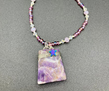 Load image into Gallery viewer, This sophisticated trapezoid-shaped wired amethyst pendant featuring a hematite star bead provides a unique, star-studded night sky look. Multicolored glass beads in shades of pink, purple, blue and gold feature along a single-stranded necklace, intermixed with larger, soft dusty rose glass beads and iridescent beads for a subtle shimmer. Necklace is 17" length can be adjusted to 18"