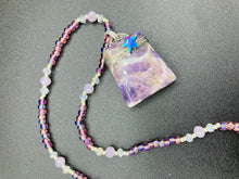 Load image into Gallery viewer, This sophisticated trapezoid-shaped wired amethyst pendant featuring a hematite star bead provides a unique, star-studded night sky look. Multicolored glass beads in shades of pink, purple, blue and gold feature along a single-stranded necklace, intermixed with larger, soft dusty rose glass beads and iridescent beads for a subtle shimmer. Necklace is 17" length can be adjusted to 18"