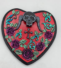 Load image into Gallery viewer, This Memento Mori Wall Art Decor is a one-of-a-kind art piece, skillfully crafted with a black polymer clay skull and wings on a dark red wood frame, decoratively woven with dark red roses and vines. It's perfect for adding an eye-catching touch to any wall and makes a unique, bold gift. Measurements: H 6 3/4" x W 7” x D 1 1/2"
