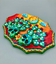 Load image into Gallery viewer, This handcrafted polymer clay wall art features a wood frame painted in a gradient from light yellow to dark red, creating a stunning sunset look. With two bright green skull cactus plant and bright dark red blooming flowers. Featuring a vivid sun and crescent moon with a backdrop of light blue clouds, this frame is sure to make an impression. A bight green hue frame to make a bold contrast with the warm background hue. This piece is sure to make a statement.