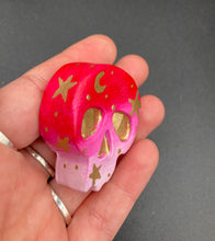 Load image into Gallery viewer, Inspired by nature, this skull statuette is full of vibrant colors and intricate details. The ombre colors from red, to light pink was inspired by the summer sky at sundown that I see all too often. I really wanted to capture those beautiful colors and added metallic gold moon and stars silhouettes to tie it all together.