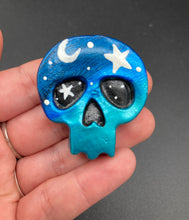 Load image into Gallery viewer, Ideal magnet design to adorn your refrigerator, lockers, workstation, toolbox, or dishwasher. This hand-sculpted clay skull statuette boasts stunning ombre coloration, transitioning from dark blue to light blue to recreate the breathtaking look of a starry night sky. H 1 1/2” x W 1 1/2” x D 3/4”