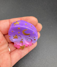Load image into Gallery viewer, Ideal magnet design to adorn your refrigerator, lockers, workstation, toolbox, or dishwasher. This unique skull statuette features intricate details and vibrant colors, inspired by the summer sky at sundown. Variations in color from purple to light pink simulate the dramatic ombre seen in a setting sun, completed with golden stars and moon silhouettes for a celestial touch. H 1 1/2” x W 1 1/2” x D 3/4”
