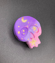 Load image into Gallery viewer, Perfect magnet design to adorn your refrigerator, lockers, workstation, toolbox, or dishwasher. This unique skull statuette features intricate details and vibrant colors, inspired by the summer sky at sundown. Variations in color from purple to light pink simulate the dramatic ombre seen in a setting sun, completed with golden stars and moon silhouettes for a celestial touch.   H 1 1/2” x W 1 1/2” x D 3/4”