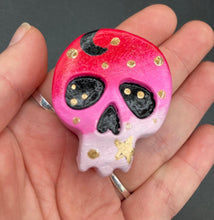 Load image into Gallery viewer, Ideal magnet design to adorn your refrigerator, lockers, workstation, toolbox, or dishwasher. This intricately detailed skull statuette is inspired by the beauty of nature, with vibrant colors ranging from red to a light pink reminiscent of a summer sky at dusk. A black moon and gold stars were added to provide a unified aesthetic. H 1 1/2” x W 1 1/2” x D 3/4”